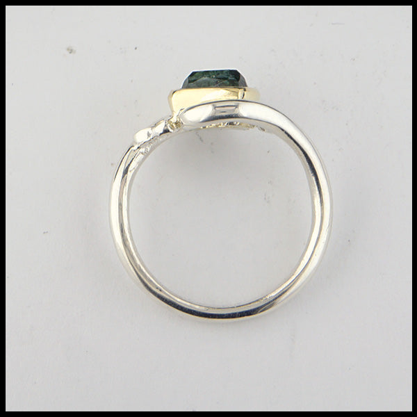 Profile view of rustic hand fabricated ring in sterling silver with an 18K yellow gold bezel, set with a Rose Cut  Green Tourmaline with trinity knot accents.