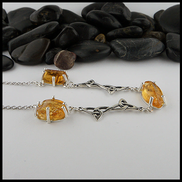 Profile view of custom Celtic Pendant with 3 links set with freeform cabochon Citrine and two trinity knot links. 