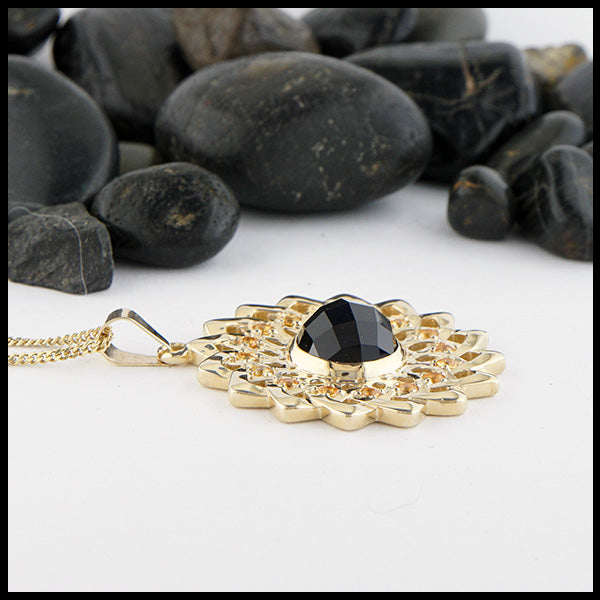 14K Yellow gold sunflower pendant set with 16 yellow sapphires and a center rose cut onyx on a 14K Yellow Gold Light Curb Chain.