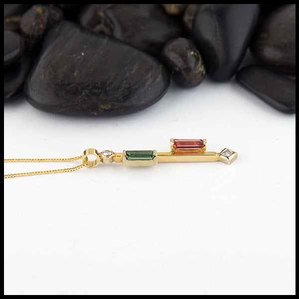 Profile view of Custom pendant in 14K Yellow Gold set with a 0.46ct pink tourmaline, and a  0.34ct green tourmaline, with 0.10ct total weight of accent diamonds.