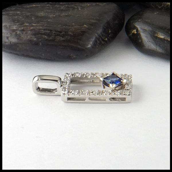 Profile view of Diamond and sapphire pendant in 14K White gold