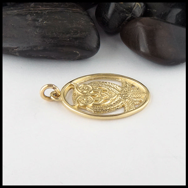 Profile view of owl pendant in gold
