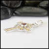 Profile view of garnet cross in silver and gold