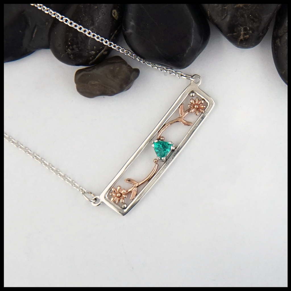 Custom Flower Necklace in Sterling Silver with 14K Rose Gold flowers, set with a green Emerald. 
